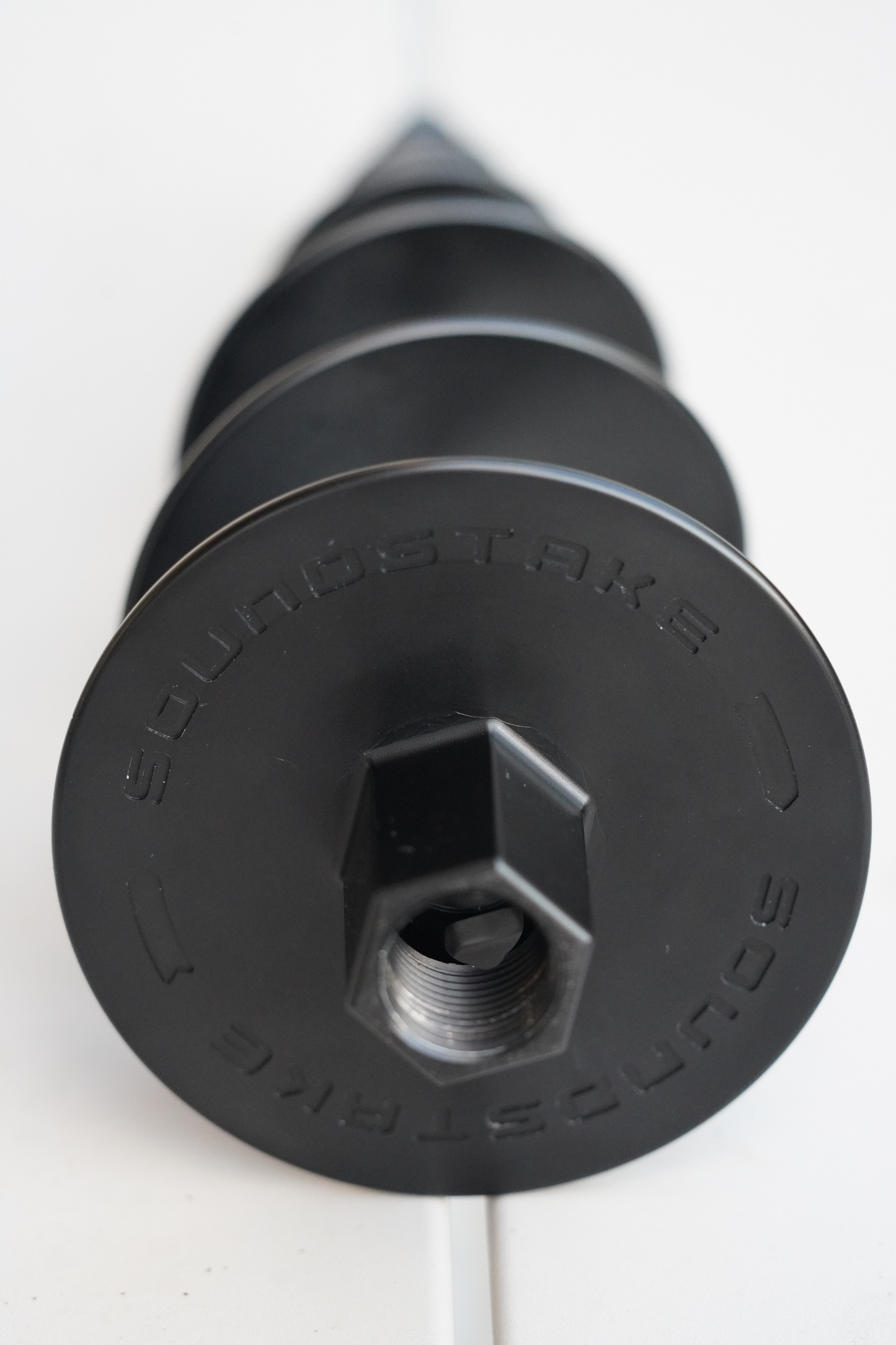 A black SoundStake SS-10-AL-PC-BL, which is a stake designed to secure landscape speakers in the ground.